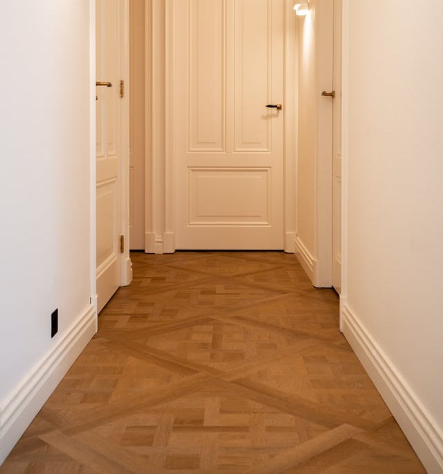 Gang met paneeldeuren en een Versailles-vloer
