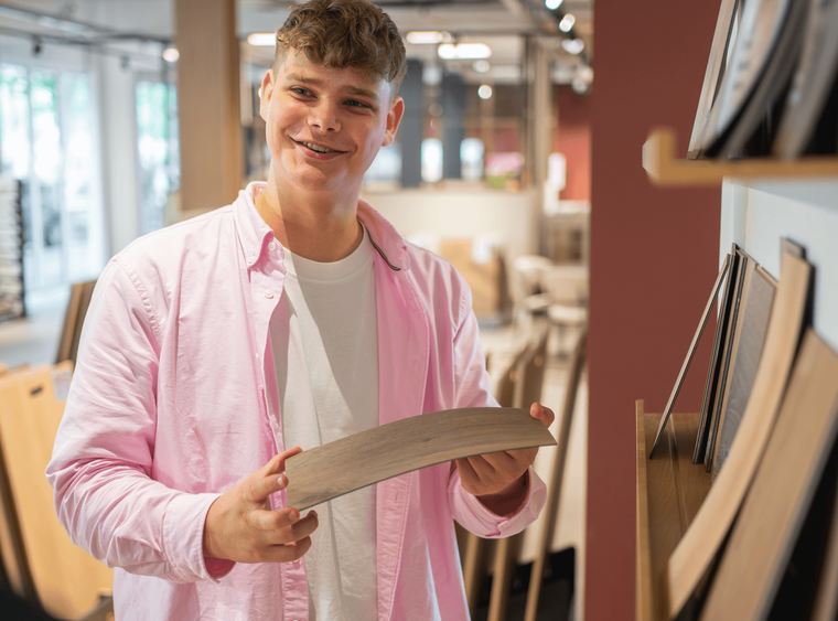 Solza-medewerker laat een vloerstaal zien in de showroom in Alphen aan den Rijn